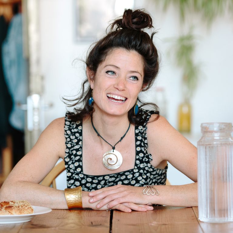 Woman smiling with dark hair and high bun tide up