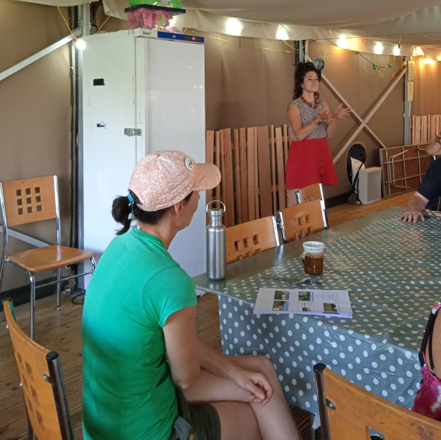 Women standing in front of table talking to the audience.