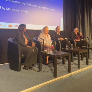 four women sitting on a stage for a panel discussion