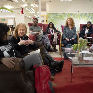 A group of women sitting down and talking