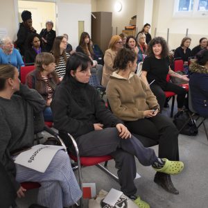 A group of women sitting in a room at a hustings event.